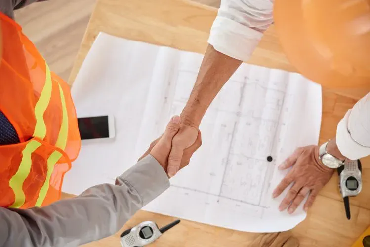 A contractor shakes hands with a client.
