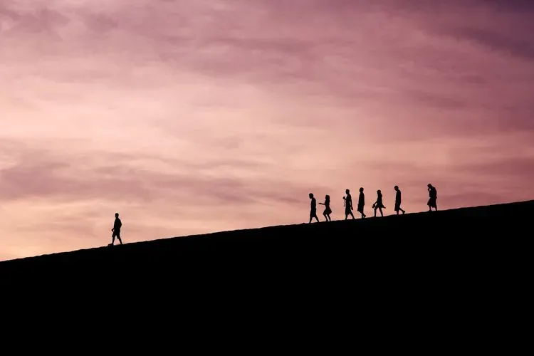 A leader walking a team down a hill.