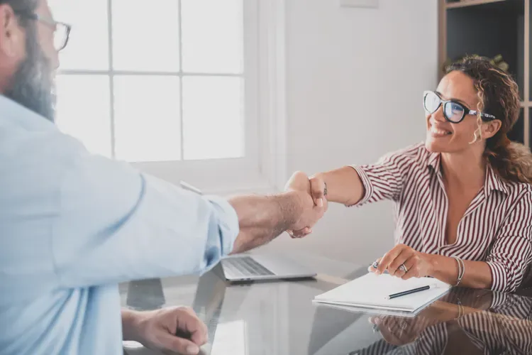A restoration manager shakes hands with an applicant.