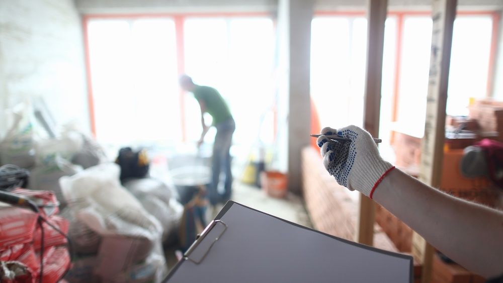 An estimator carries a clipboard on a jobsite.