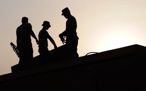 The silhouette of restoration workers on a roof.