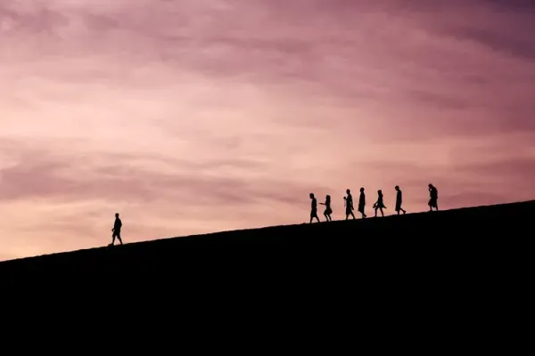 A leader walking a team down a hill.