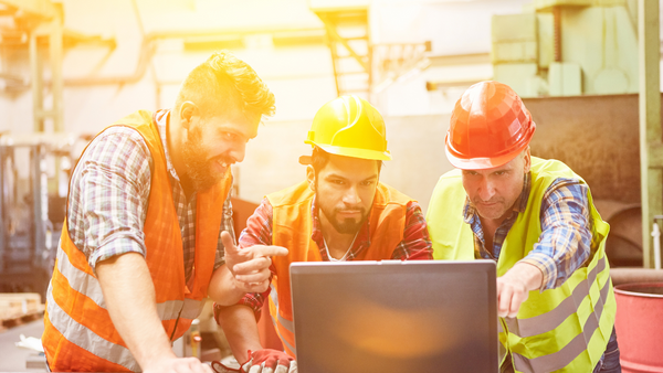 3 construction workers using a computer