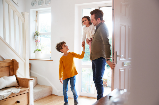 A father and his children walking into a home